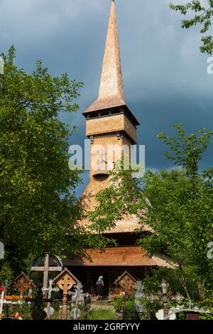 Romania, regione di Maramures, Desesti, chiesa di legno di Paraskeva, chiesa dichiarata patrimonio mondiale dell'UNESCO, cimitero Foto Stock