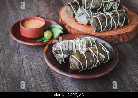 arem-arem, un alimento tradizionale indonesiano, ripieno di riso avvolto in foglie di banana, bollito fino a cottura, ripieno di manzo o pollo stagionato Foto Stock