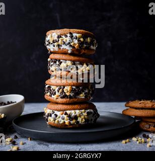 Impila di biscotti al cioccolato con scaglie di gelato su un piatto. Foto Stock