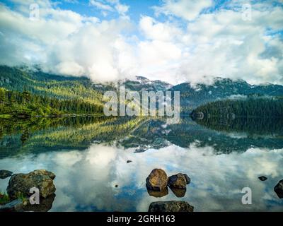 Mattina presto sul lago Callaghan con un riflesso perfettamente tranquillo in Whistler British Columbia Canada Foto Stock