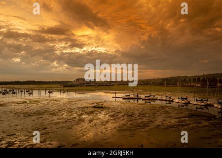 Barche ormeggiate nel porto di Portsmouth a bassa marea, crepuscolo con cielo moody. Foto Stock