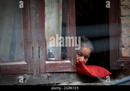 Kathmandu, Bagmati, Nepal. 1 ottobre 2021. Una donna anziana guarda fuori dalla finestra dalla sua casa a Kathmandu, Nepal il 1 ottobre 2021. Il 14 dicembre 1990, l'Assemblea Generale delle Nazioni Unite ha designato il 1 ottobre di ogni anno come Giornata Internazionale delle persone anziane. (Credit Image: © Sunil Sharma/ZUMA Press Wire) Foto Stock