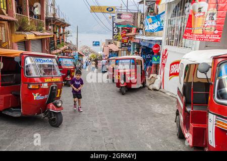 SANTIAGO ATITLAN, GUATEMALA - 24 MARZO 2016: Fila di tuk tuk su una strada nel villaggio di Santiago Atitlan. Foto Stock