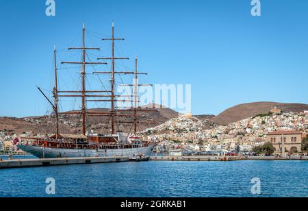 Isola di Syros, Grecia - Settembre 17 2021: Il lussuoso yacht Sea Cloud ormeggiato al porto, con Ermoupolis e Ano Syros sullo sfondo. Foto Stock