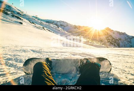 Snowboarder seduto al tramonto in un momento di relax nella stazione sciistica delle alpi francesi - concetto di sport invernale con ragazzo avventura in cima alla montagna pronto per il giro Foto Stock