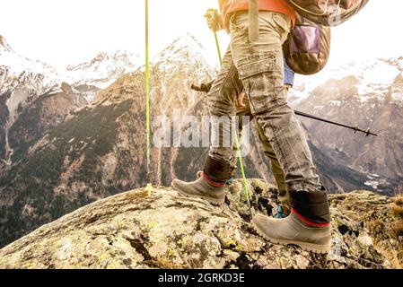 Primo piano di trekking gambe e stivali sulle alpi francesi - Hiker con zaini e bastoni a piedi sulla montagna - Wanderlust viaggio concetto Foto Stock