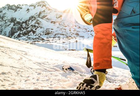 Sciatore professionista al tramonto che tocca la neve in un momento di relax nella stazione sciistica delle alpi francesi - concetto di sport invernale con ragazzo avventura in cima alla montagna Foto Stock