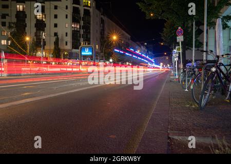 Strade urbane immagine di sfondo di notte con luci sfocate e sfocate, Friedrichstrasse a Berlino, Germania. Foto Stock
