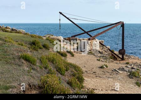 Gru arrugginita lungo la costa di pietra a Portland Bill, Isle of Portland, Dorset, Inghilterra, Regno Unito Foto Stock
