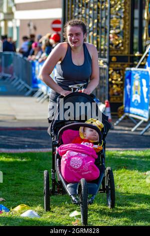 Warrington Running Festival 2021 - la donna spinge la figlia del bambino oltre il traguardo Foto Stock