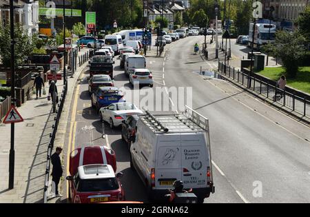 Le code di traffico bloccano la strada in entrambe le direzioni poiché i conducenti attendono lunghi periodi per entrare in una stazione di benzina. Autobus e altro traffico non può guidare passato. Si è verificato un inceppamento nel registro. Una carenza di conducenti di consegne ha creato una crisi in tutto il paese e ha portato a discussioni tra i conducenti in competizione per il carburante. Questo è il settimo giorno in cui questo ingorgo di traffico esisteva su questa strada di Londra. Un conducente ha esaurito il carburante durante l'attesa in coda e riceve assistenza da un veicolo di recupero. Foto Stock