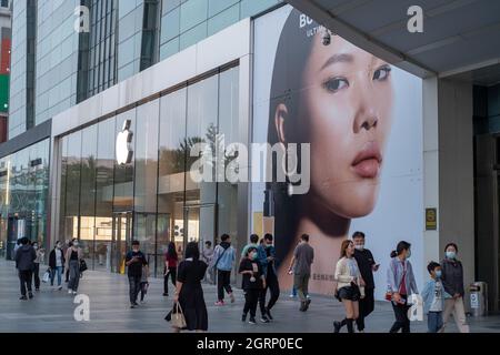 I consumatori cinesi camminano oltre l'etichetta di moda britannica Burberry ad vicino ad un negozio Apple a Pechino, Cina.01-Ott-2021 Foto Stock