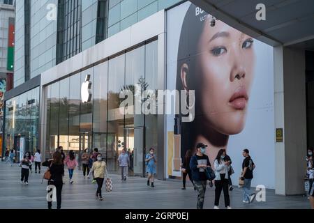 I consumatori cinesi camminano oltre l'etichetta di moda britannica Burberry ad vicino ad un negozio Apple a Pechino, Cina.01-Ott-2021 Foto Stock