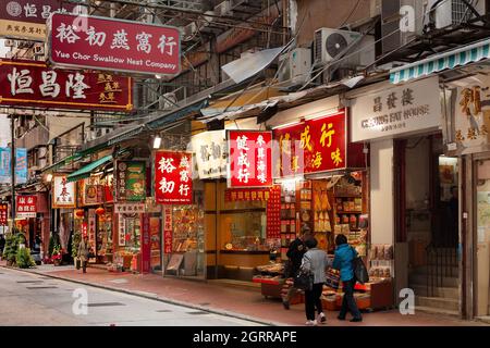 Sheung WAN, Hong Kong Island, Hong Kong, Cina, Asia - Negozi e canta in una strada commerciale a Hong Kong occidentale. Foto Stock