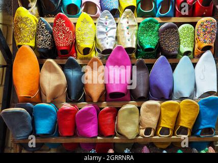 Pantofole in pelle colorata fatte a mano in mostra presso il tradizionale souk - mercato di strada in Marocco Foto Stock