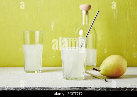 Bevanda a base di pera, cocktail in un bicchiere con una cannuccia. Foto Stock