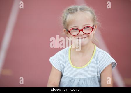 Una ragazza con sindrome di Down è coinvolta in atletica Foto Stock