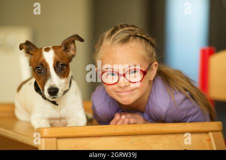 Bella ragazza con una sindrome di Down con il suo animale domestico Jack Russell Terrier Foto Stock