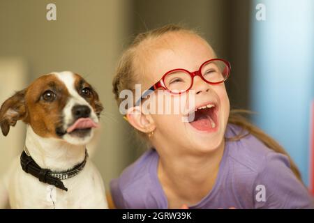 Bella ragazza con una sindrome di Down con il suo animale domestico Jack Russell Terrier Foto Stock