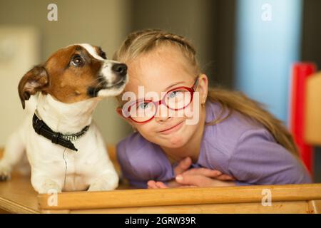 Bella ragazza con una sindrome di Down con il suo animale domestico Jack Russell Terrier Foto Stock