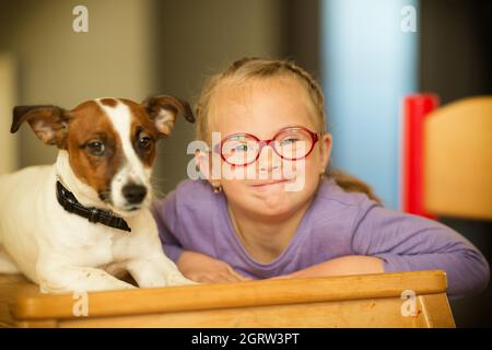 Bella ragazza con una sindrome di Down con il suo animale domestico Jack Russell Terrier Foto Stock