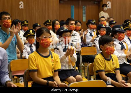 Hong Kong, Cina. 01 ottobre 2021. Una giovane studentessa si stringe le mani, durante la cerimonia. Le attività educative nazionali e la cerimonia di sollevamento della bandiera si sono tenute in una scuola secondaria a Siu sai WAN. Mentre i funzionari governativi di Cina e Hong Kong stanno eliminando qualsiasi segno di dissenso dall'istituzione della legge sulla sicurezza nazionale, è stata formata una nuova forma di istruzione nazionale in cui agli studenti viene insegnato ad essere più patriottici e ad avere una fedeltà sensibile alla loro patria. (Foto di Alex Chan Tsz Yuk/SOPA Images/Sipa USA) Credit: Sipa USA/Alamy Live News Foto Stock