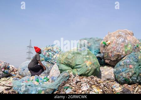 Nakuru, Kenya. 01 ottobre 2021. Una donna è vista smistare i rifiuti delle bottiglie di plastica nel sito di scarico di Gioto per essere portato in un impianto di riciclaggio vicino.il problema crescente dei rifiuti di plastica che finiscono nell'ambiente sta diventando una preoccupazione e gli ambientalisti stanno chiedendo più investimenti nelle infrastrutture per riciclare la plastica per promuovere circolare economia e ridurre l'inquinamento della plastica. Essi chiedono inoltre al governo di introdurre un sistema obbligatorio di deposito e rimborso delle bottiglie (DRS) che darà valore alle bottiglie di plastica per bevande comunemente note come animali da compagnia (polietilentereftalato). Rimborso del deposito sc Foto Stock