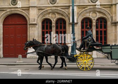 30 maggio 2019 Vienna, Austria - carrozza di cavalli nella strada vicino al Teatro dell'Opera di Vienna (Wiener Staatsoper). Nuvoloso giorno primaverile Foto Stock