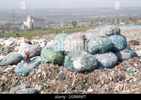 Nakuru, Rift Valley, Kenya. 1 ottobre 2021. Le donne sono viste smistare i rifiuti delle bottiglie di plastica nel sito di scarico di Gioto per essere portati in un impianto di riciclaggio vicino.il problema crescente dei rifiuti di plastica che finiscono nell'ambiente sta diventando una preoccupazione e gli ambientalisti stanno chiedendo più investimenti nelle infrastrutture per riciclare la plastica per promuovere l'economia circolare e ridurre l'inquinamento della plastica. Essi chiedono inoltre al governo di introdurre un sistema obbligatorio di deposito e rimborso delle bottiglie (DRS) che darà valore alle bottiglie di plastica per bevande comunemente note come animali da compagnia (polietilentereftalato). Cr. DEP Foto Stock