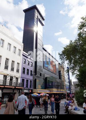 Londra, Grande Londra, Inghilterra, settembre 21 2021: Persone che camminano rilassante e lettura di fronte al famoso Odeon Cinema in Leicester Square. Foto Stock