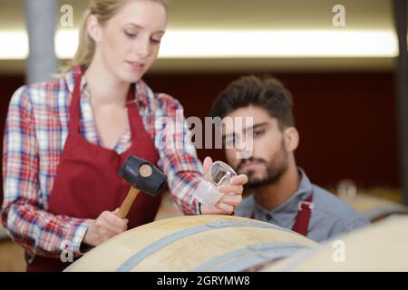 produttori di vino con ispezione a martello in cantina Foto Stock