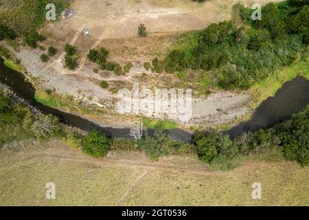 Creek che si snoda attraverso il paesaggio di campagna, drone vista aerea in prospettiva Foto Stock