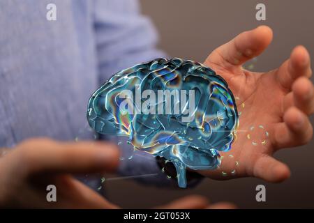 rendering 3d di un cervello umano futuristico e di una mano maschile su uno sfondo sfocato Foto Stock