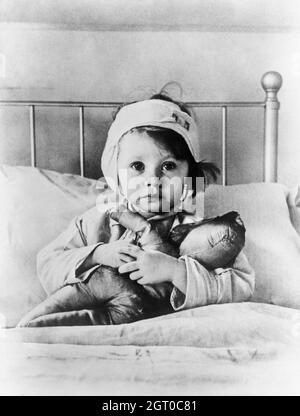 Eileen Dunne, di tre anni, siede a letto con la bambola al Great Ormond Street Hospital for Sick Children, dopo essere stato ferito durante un raid aereo a Londra nel settembre 1940. Foto di Cecil Beaton Foto Stock