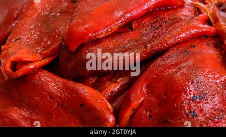 Peperoni rossi – appena tostati e sbucciati. Raccolta di peperoni rossi coltivati naturalmente nel giardino di casa per un sano cibo di famiglia. Foto Stock