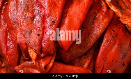 Peperoni rossi – appena tostati e sbucciati. Raccolta di peperoni rossi coltivati naturalmente nel giardino di casa per un sano cibo di famiglia. Foto Stock