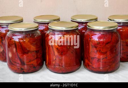 Peperoni rossi tostati e sbucciati sterilizzati in casa. Completamente naturale, biologico, appena selezionato dal giardino di casa. Foto Stock