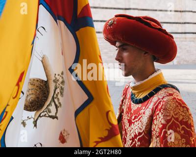 Siena, Italia - Agosto 15 2021: Portatore standard o portatore di bandiera del Commercio della lumaca, pagina recante il Banner della Contrada della Chiocciola e W. Foto Stock