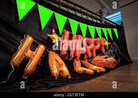 Happy Halloween arancione palloncino lettere sono preparati il 2 ° pavimento per appendere sulla terrazza con bandiera di zucca E sfondo in tessuto nero in Hallowe Foto Stock