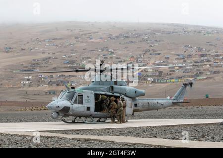 Marines USA con Special Purpose Marine Air-Ground Task Force – UNITAS e nazioni partner, entrare in un elicottero UH-1Y Venom durante un'evoluzione di addestramento veloce-corda alla Peruvian Marine Corps base Ancon, Perù, 26 settembre 2021, durante l'esercizio UNITAS LXII. Stati Uniti, Brasile, Cileno, Colombiano, Messico, E i marines peruviani e i membri della forza di difesa giamaicana hanno completato una serie di eventi formativi per costruire fiducia, aumentare la fiducia e rafforzare l'interoperabilità per prepararci meglio a una risposta combinata e multinazionale alle crisi emergenti o alle catastrofi naturali. UNITAS è l Foto Stock