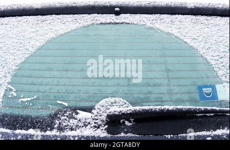 primo piano della parte posteriore dell'auto ghiacciata con parabrezza e tergicristallo ghiacciati in una mattinata invernale nevosa Foto Stock