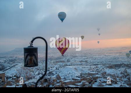 Mongolfiere che volano sopra la Cappadocia spettacolare. Splendida vista di mongolfiere che galleggiano nel cielo chiaro dell'alba sul paesaggio di montagna Foto Stock