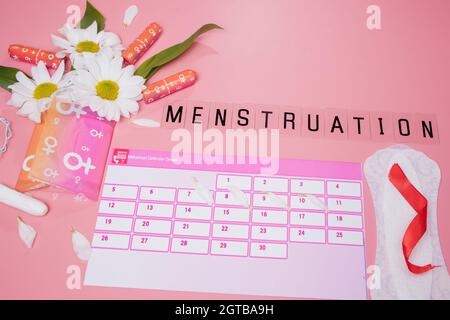 Calendario mestruazioni con tamponi di cotone , tamponi sanitari, fiore bianco . Donna giorni critici, donna igiene protezione Foto Stock