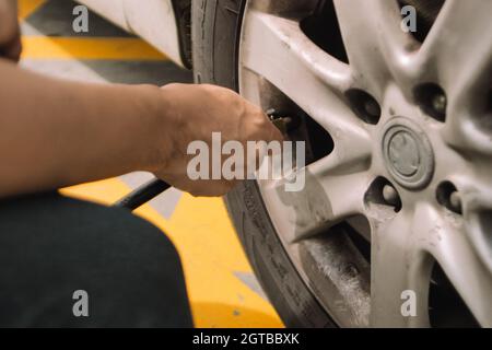 Man Hand che lavora con la macchina del sistema di riempimento di pneumatici di azoto in pneumatico di automobile Foto Stock