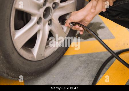 Man Hand che lavora con la macchina del sistema di riempimento di pneumatici di azoto in pneumatico di automobile Foto Stock