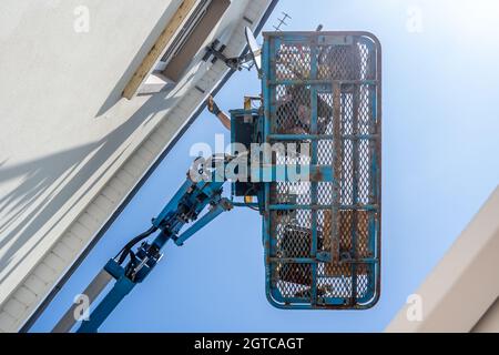 Lavoratore su una piattaforma di accesso aereo, commissionatore di ciliegie, casa di pulizia. Foto Stock