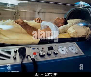Paziente sottoposto a terapia iperbarica con ossigeno in una camera pressurizzata per un solo paziente. Foto Stock