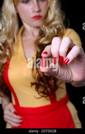 Cameriera con Red Nail Polish Holding Red pill Foto Stock