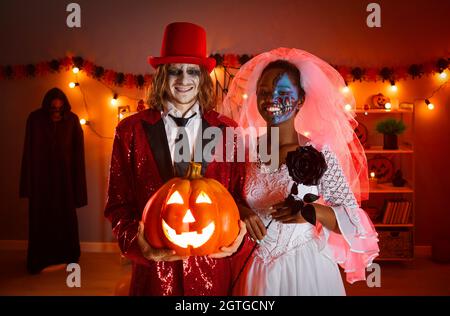 Felice giovane uomo e donna vestito come una coppia morta di nozze per una festa di Halloween Foto Stock