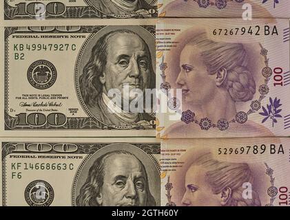 Primo piano delle banconote americane da cento dollari e delle banconote argentine da cento pesos Foto Stock